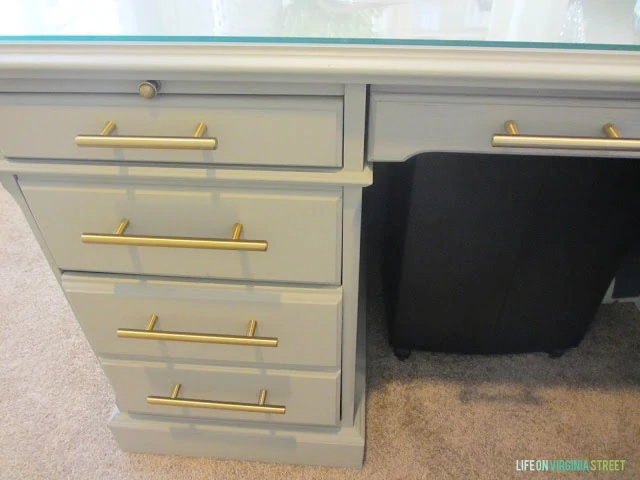A five drawer desk with the new gold handles on.