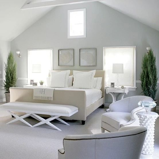 Light blue walls and neutral bedding in an A shaped master bedroom.