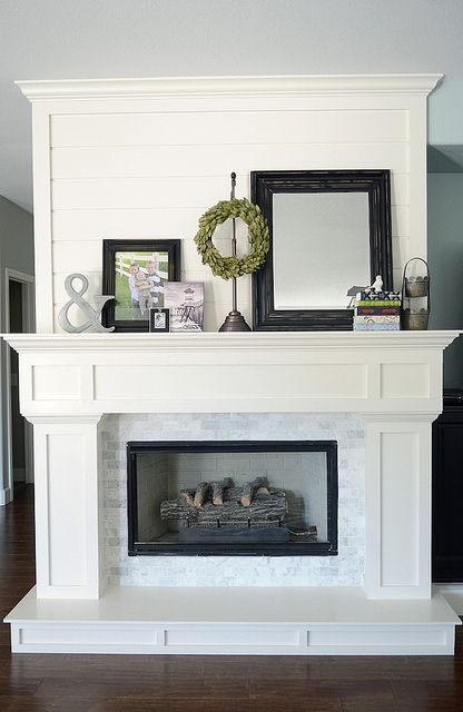 White fireplace with marble subways and shiplap trim.
