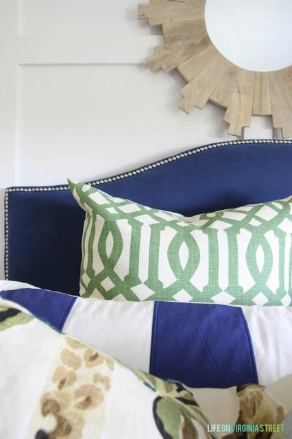 Blue headboard with blue, green and white bedding