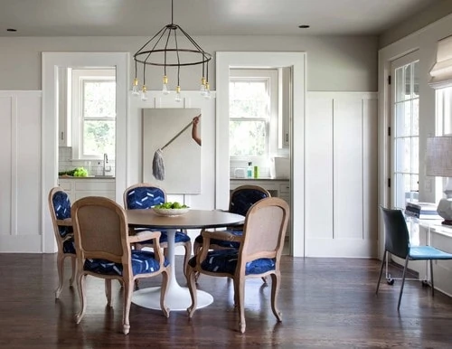Dining room featuring white batten board with blue accents on the chair. 