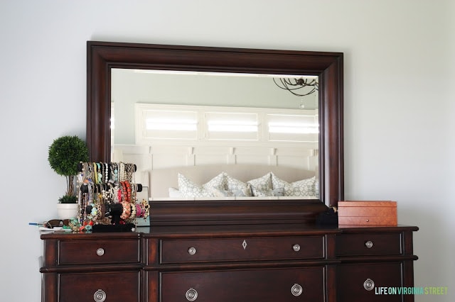 Sea salt painted bedroom walls with dark wood dresser.