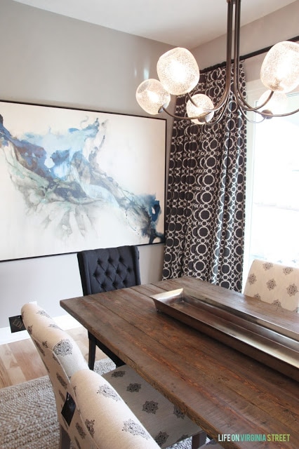 A neutral rug and brown and white curtains in the dining room.