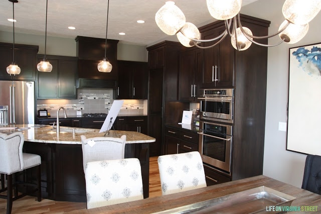 A dark wood kitchen with light coloured counters.