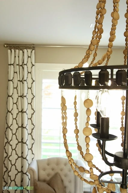 Side view of the chandelier with black and white curtains behind it.