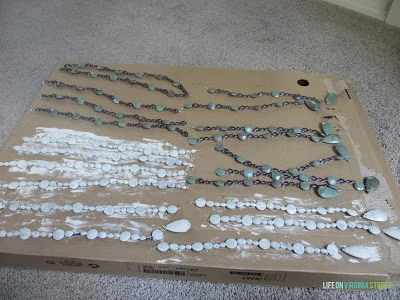 The wooden beads being painted white.