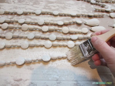 Painting the beads white with a paint brush.