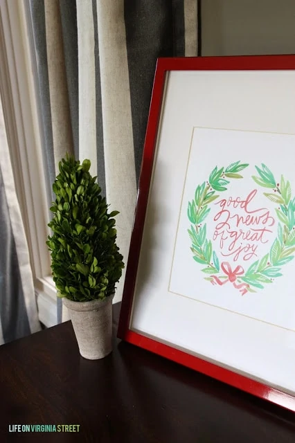A printable framed and a topiary on the side table.