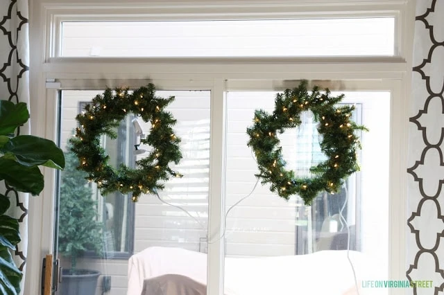 Two basic green wreaths lit up displayed on the windows.