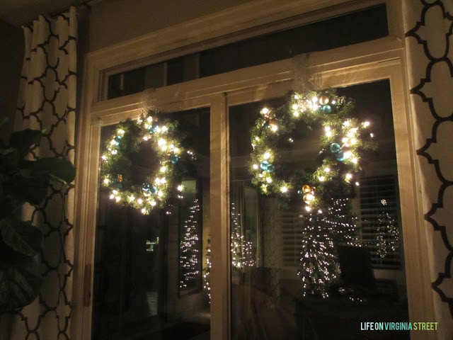 The dark living room with the lit up wreaths.