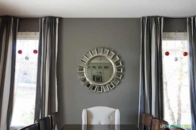 A round mirror in the dining room.