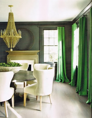 Emerald green curtains, and a wooden chandelier in dining room.