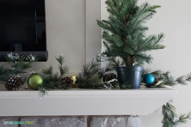 There is a small Christmas tree on the mantel.