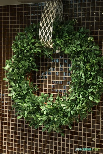 The wreath hangs in the kitchen by a ribbon.