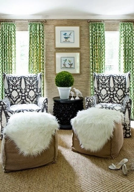 Green curtains, black and white armchairs with faux fur.   