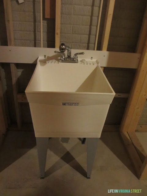 A basement with an industrial sink in it.