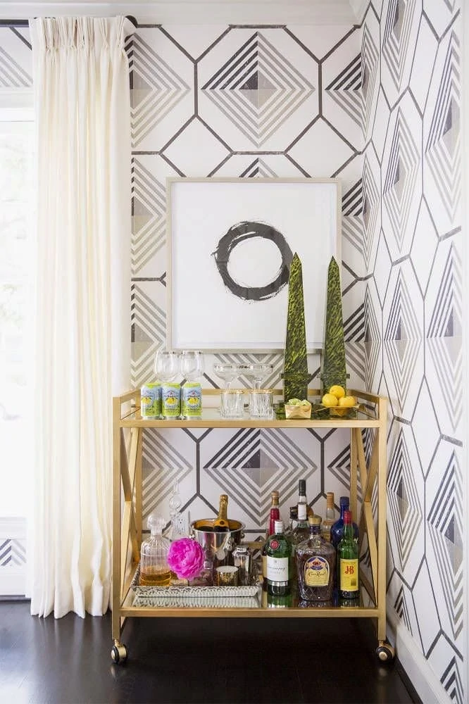 A gold bar cart in the corner of a room.