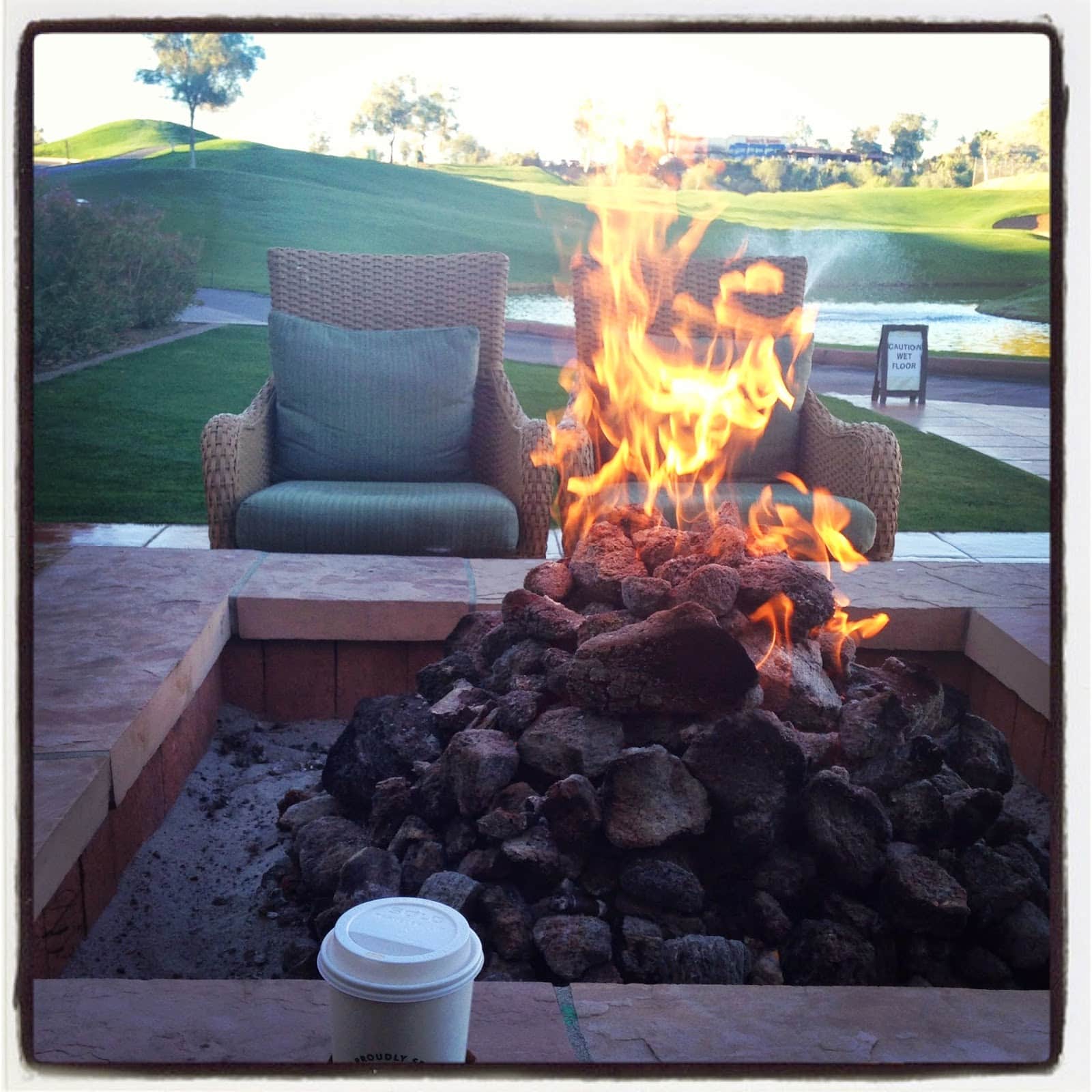 A fire pit with two chairs around it.