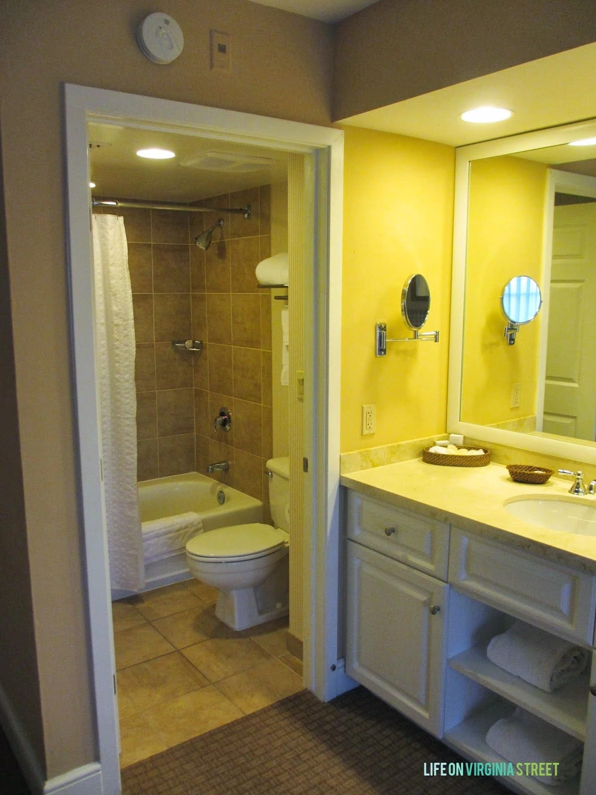 A sink and vanity plus the bathroom with a tub.