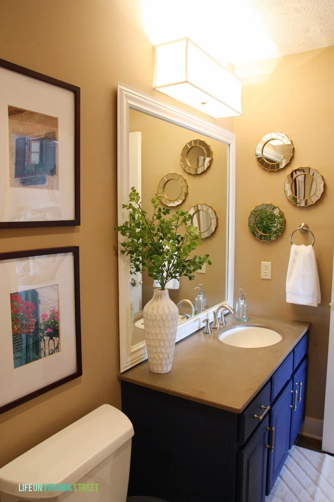In addition to making over the vanity, I also added a lot more interesting pieces and accessories to the space like these small round mirrors with gold trim and this white vase.