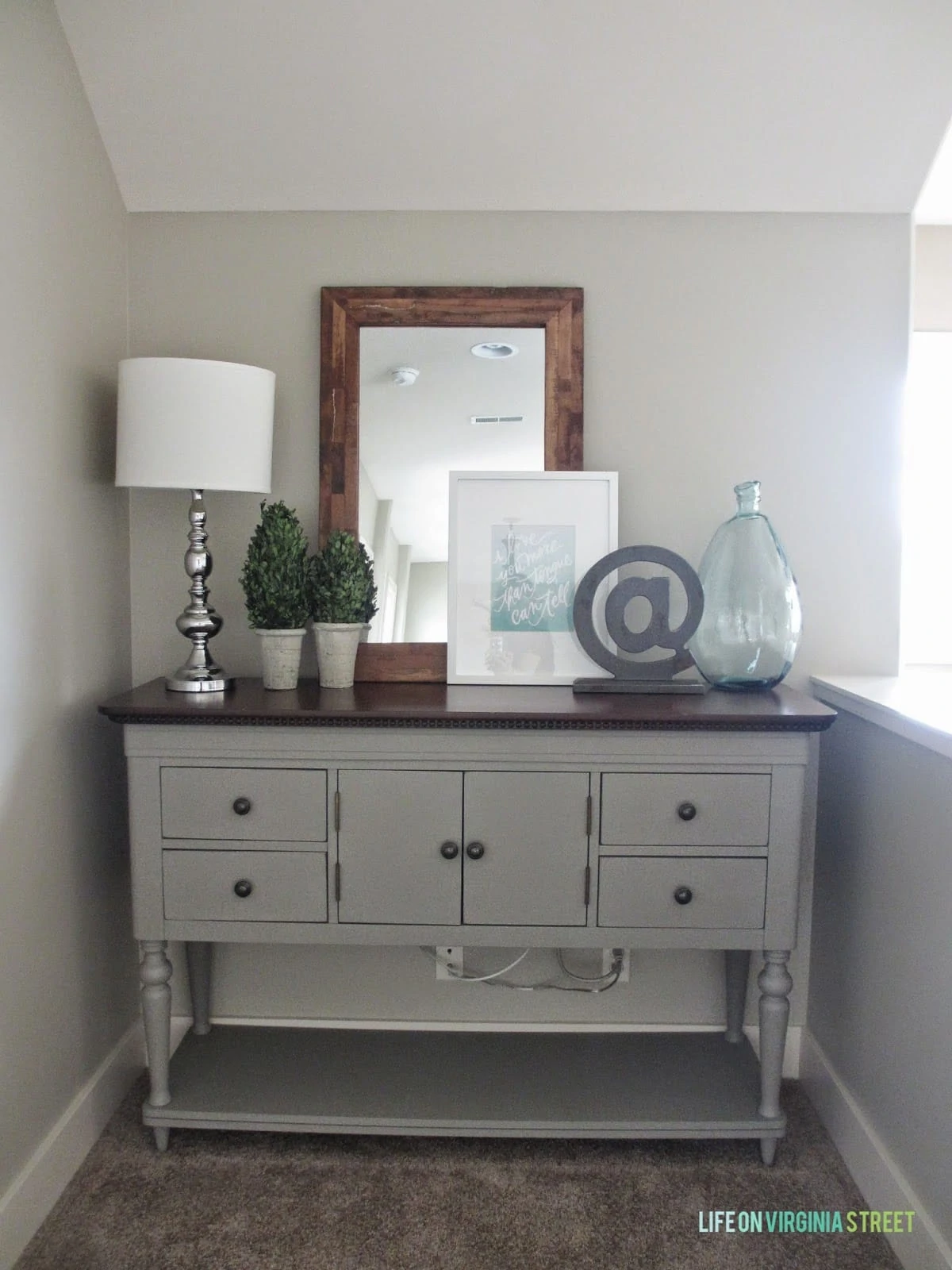 Chalk painted buffet table with Behr Castle Path painted walls. We used this painted buffet table to hide our wi-fi setup and add a little something extra to the upstairs hallway makeover.
