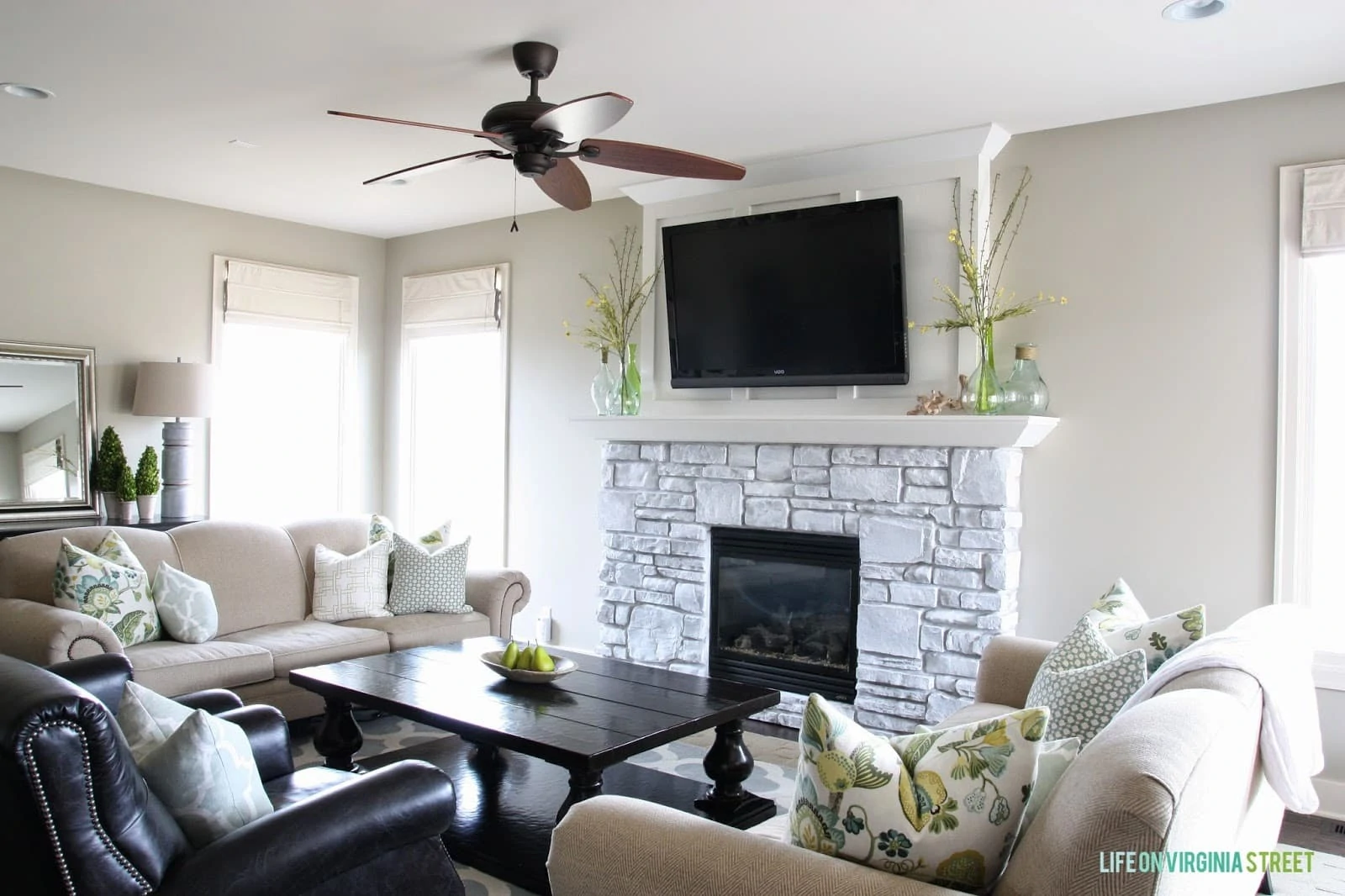 A neutral living room with a whitewashed stone fireplace!
