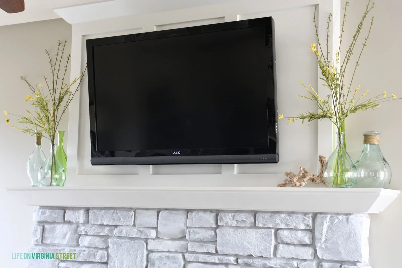 The final look- TV mounted above the updated whitewashed fireplace stone.