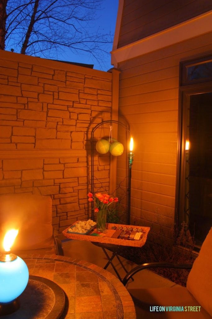 A dark night sky with a patio latern that is lighting up the patio.