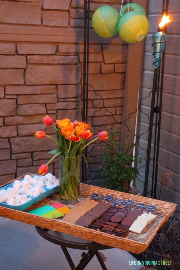 A tray filled with chocolate cookie wafers, flowers and marshmallows.