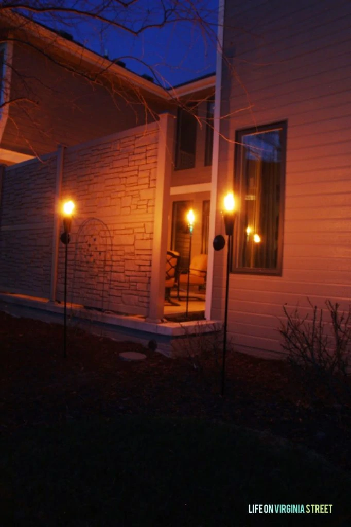 The warm glow of the outdoor lights illuminating the side of the house.