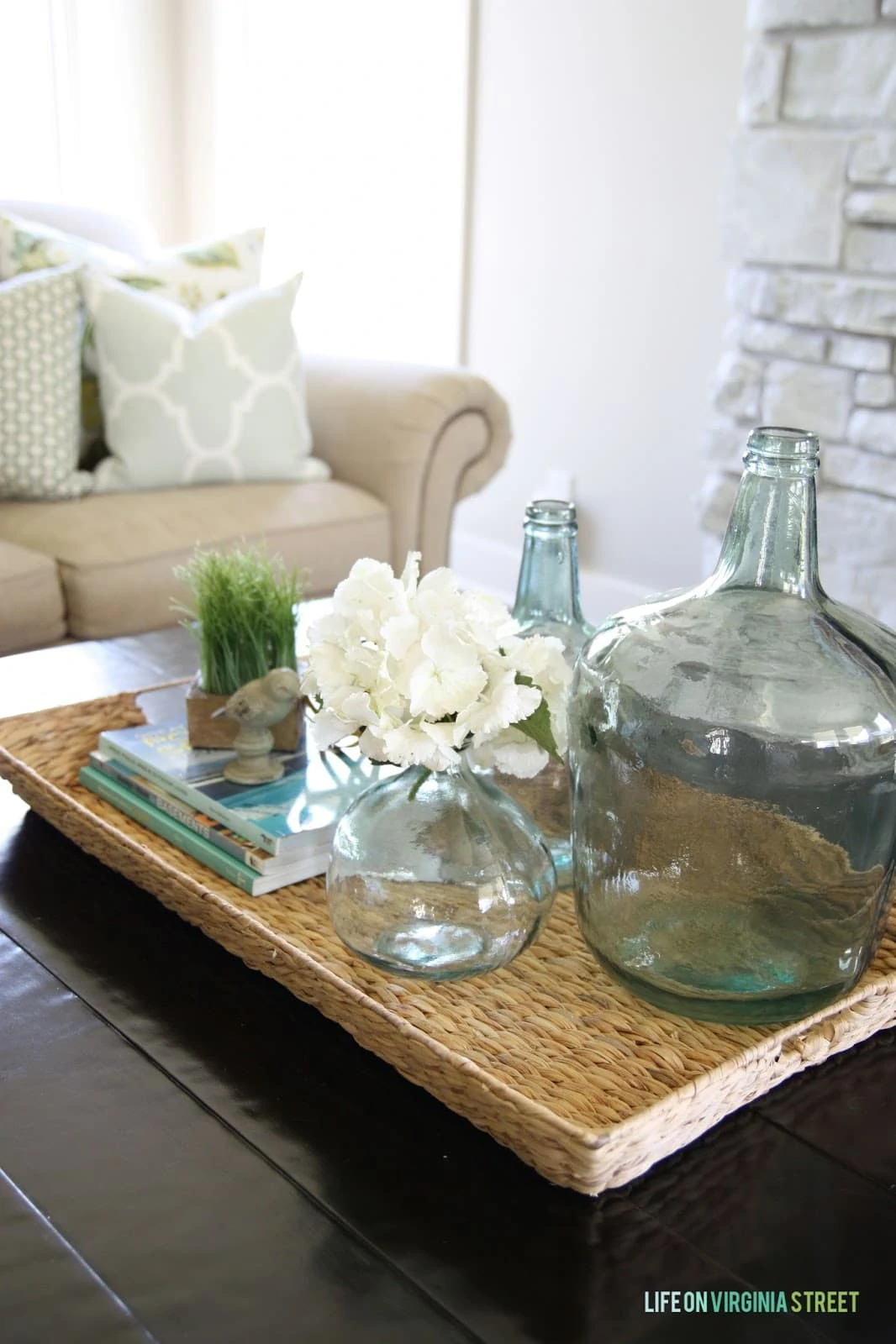Summer decor with seagrass basket, aqua bottles and white hydrangeas