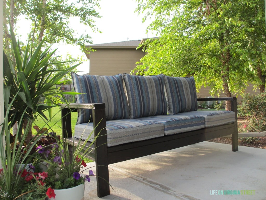 The cushions on the bench, with pots of flowers beside the couch.