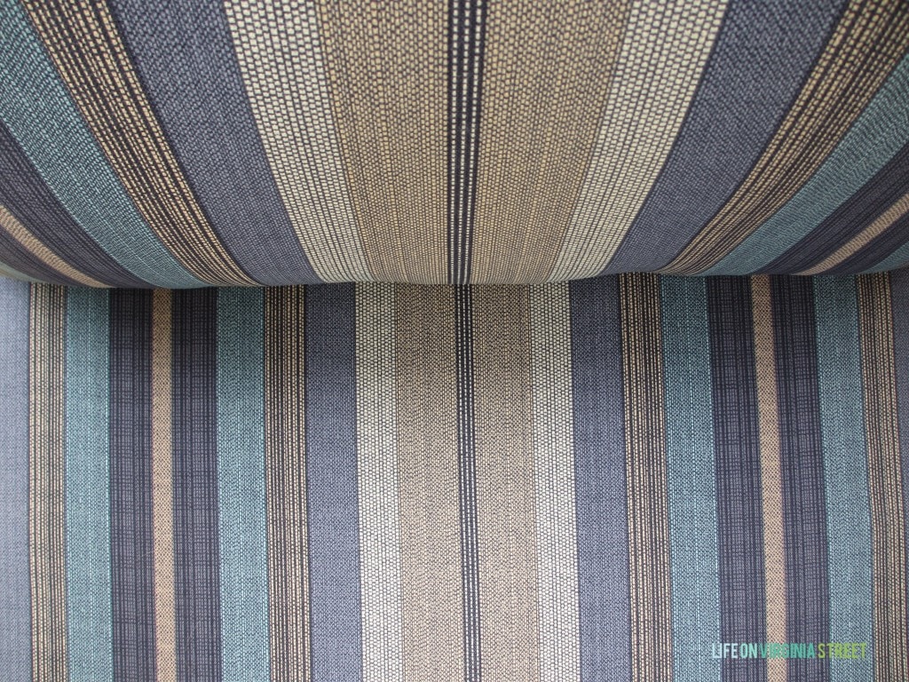 The cushions in a purple, blue, and neutral stripe.