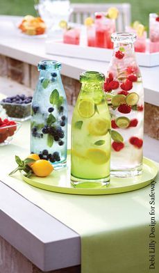 DIY lemonade station in glass pitchers on the table.