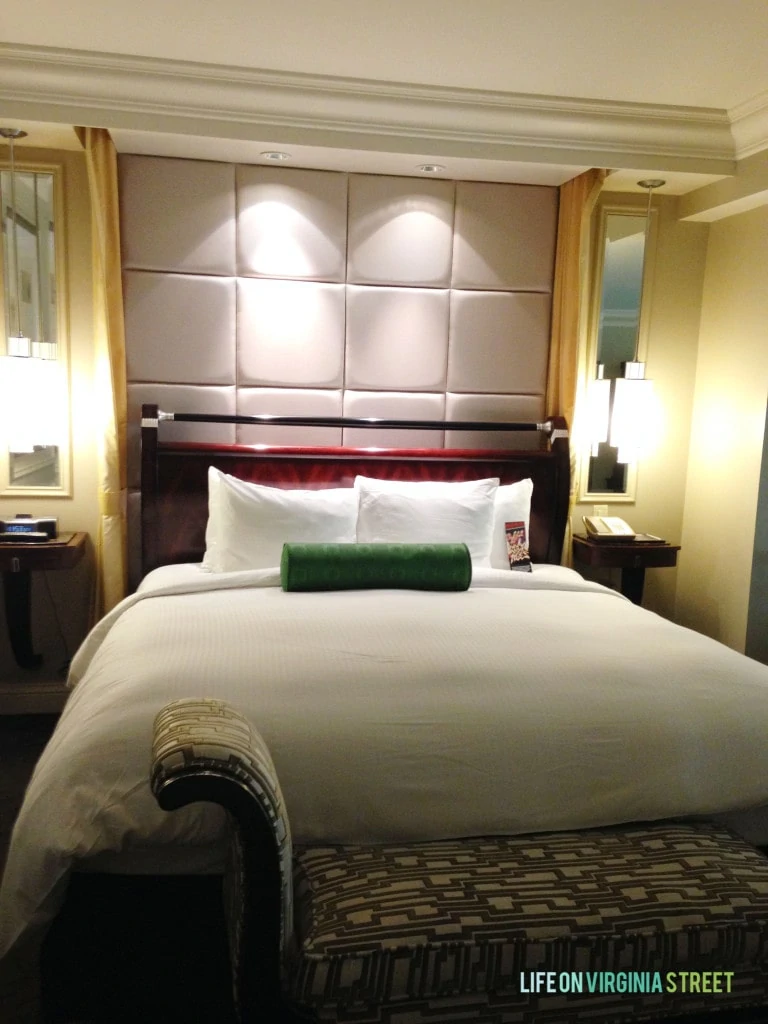 The large bed in the Venetian with a small bench at the foot of the bed.