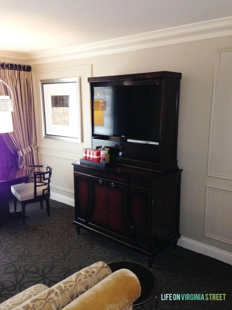 A wooden hutch in the sitting area of the hotel room.