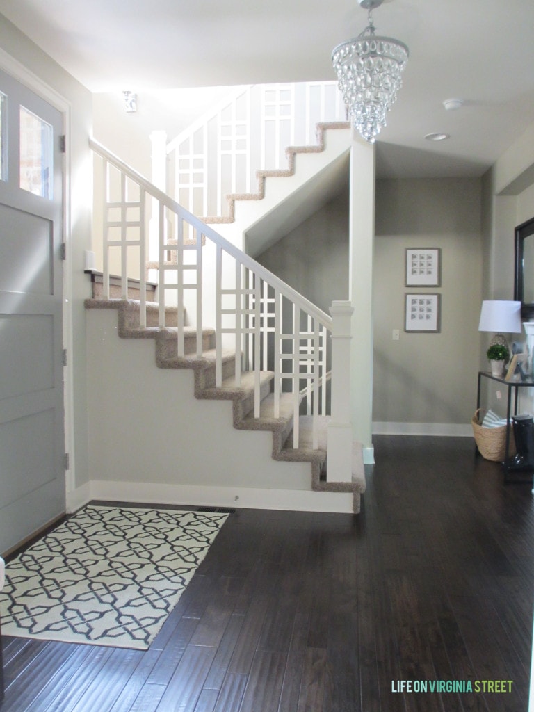 Dark wooden floor, and a winding staircase in the entryway.