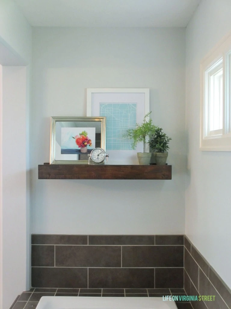 The walls painted white with a rustic shelf ledge by the tub.