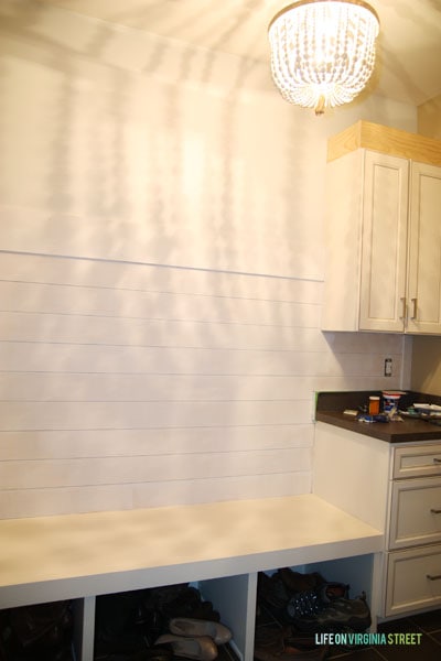 Shoes in the cubby holes of the storage bench.
