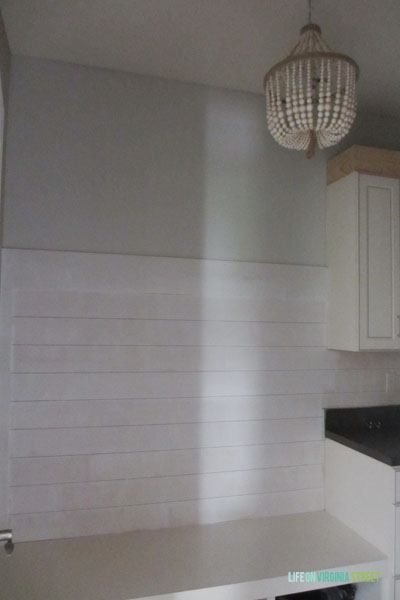 A wooden beaded chandelier in the mudroom.