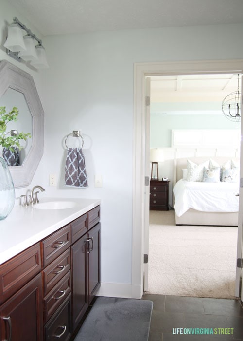 A white counter top and dark brown cabinet in the master bathroom.
