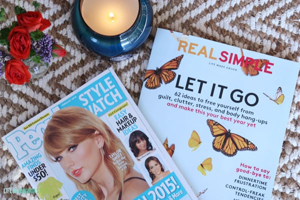 Magazines beside the candle and flowers.