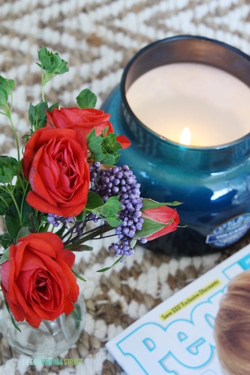 A candle and red flowers beside it.