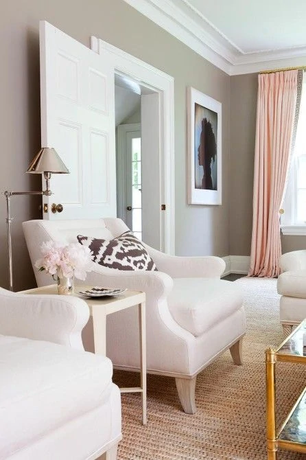 Neutral gray tones with blush pink curtains and flowers in the room.