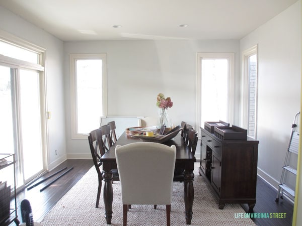 Dining room with bare walls to show off new coat of off-white paint. 