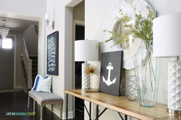 The anchor art on a wooden side table in hallway.