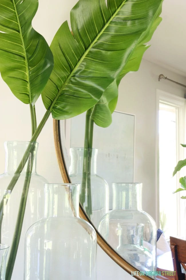 Banana leaves in beautiful glass bottles have a huge impact in this dining room makeover. 
