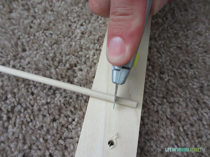 Cutting the dowel with an exacto knife.