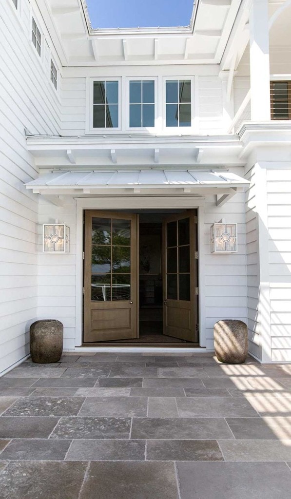 White Exterior - Metal Roof - Wood Doors. I love the stone tile here, as well as the wooden doors.