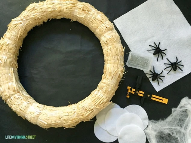 The wreath supples including the wreath, black spiders, felt, and spider web on the counter.